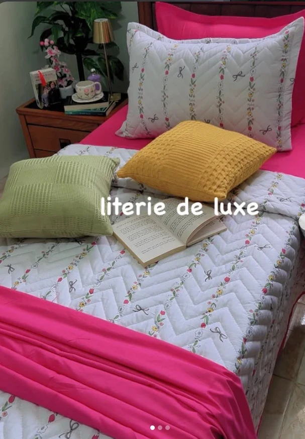 Couvre-lit matelassé fleuri avec drap fuchsia et coussins moutarde et vert